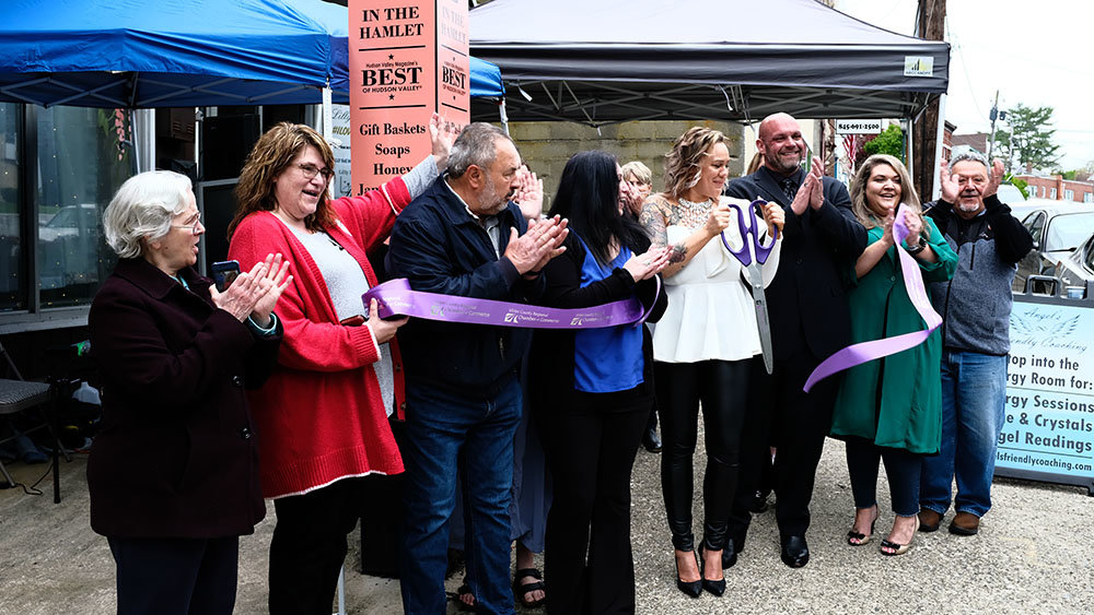 Renae Martin [in white], surrounded by friends, colleagues and elected officials, cuts a ceremonial ribbon to officially open her new location at 50 Vineyard Avenue in the hamlet of Highland.